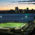 Image of a soccer pitch at night with NYC in the background