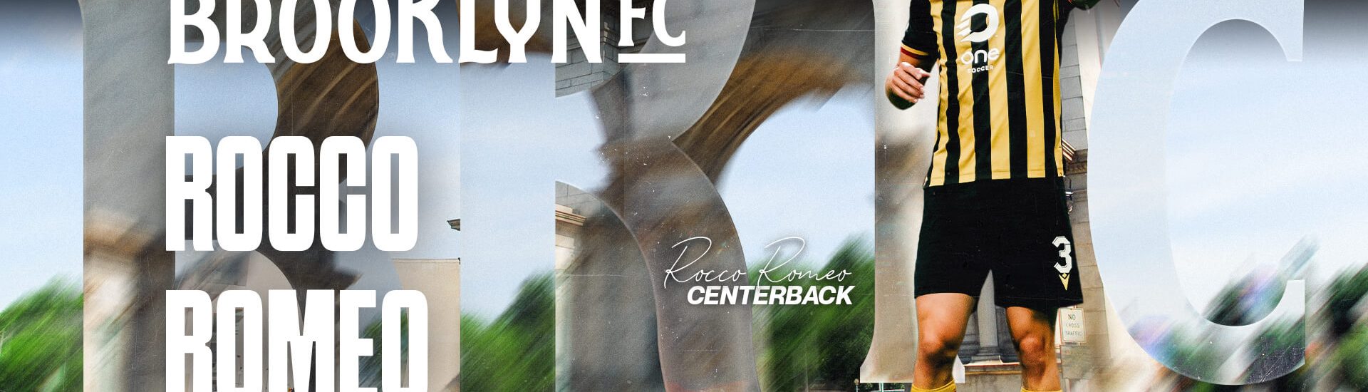 Rocco Romeo points upfield during a match, wearing a black and gold kit, in a Brooklyn FC welcome graphic.