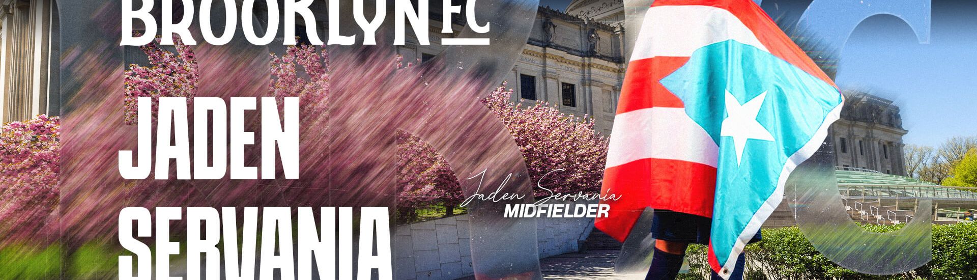 Midfielder Jaden Servania stands outside the Brooklyn Museum draped in a Puerto Rico flag, welcoming him to Brooklyn FC ahead of the club’s inaugural season.