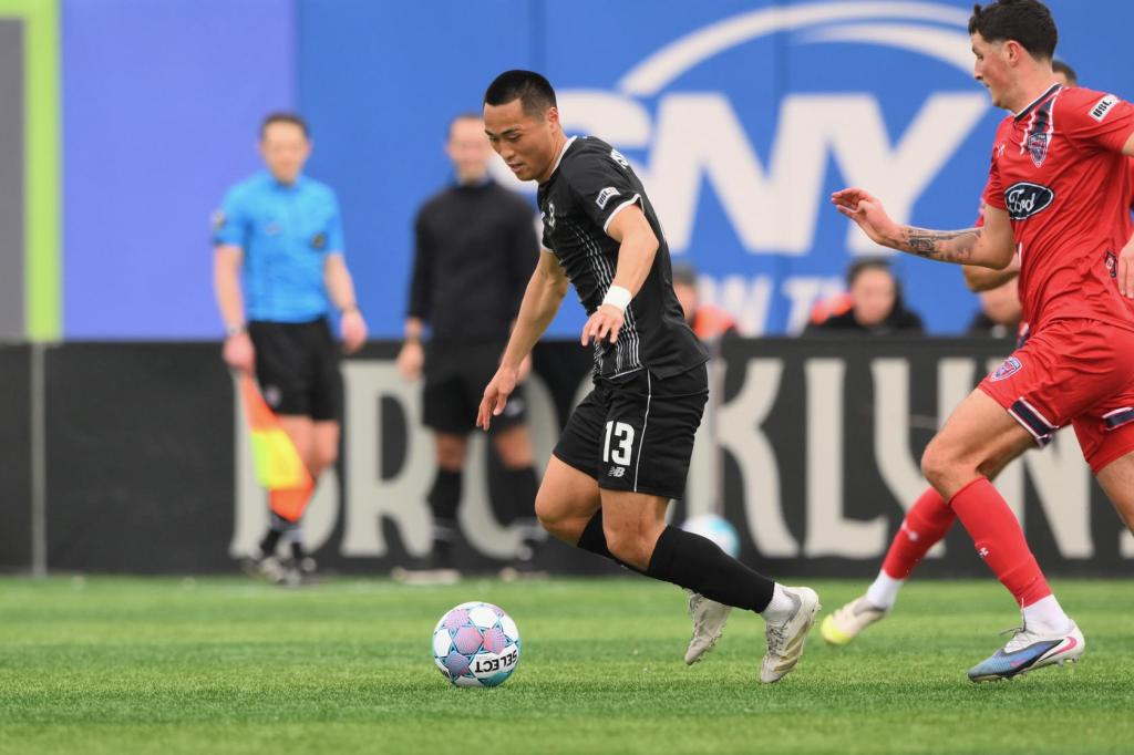 So Nishikawa dribbles the ball while pressured by the opponent.