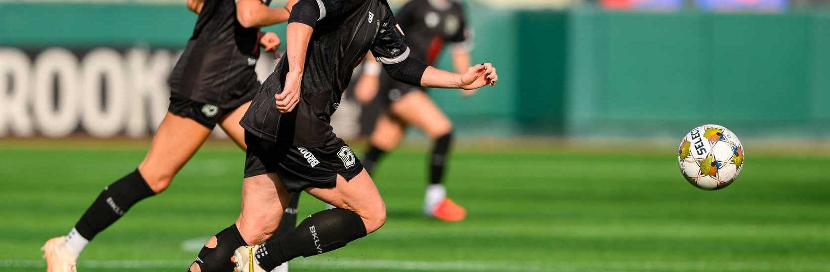 Brooklyn FC women forward Catherine Zimmerman runs onto the ball during a match while teammate Jess Garziano trails the play in the background.