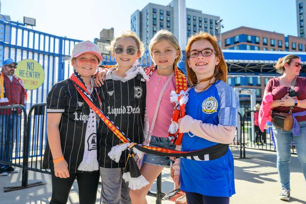 Young fans at a Brooklyn FC match cheering for their team