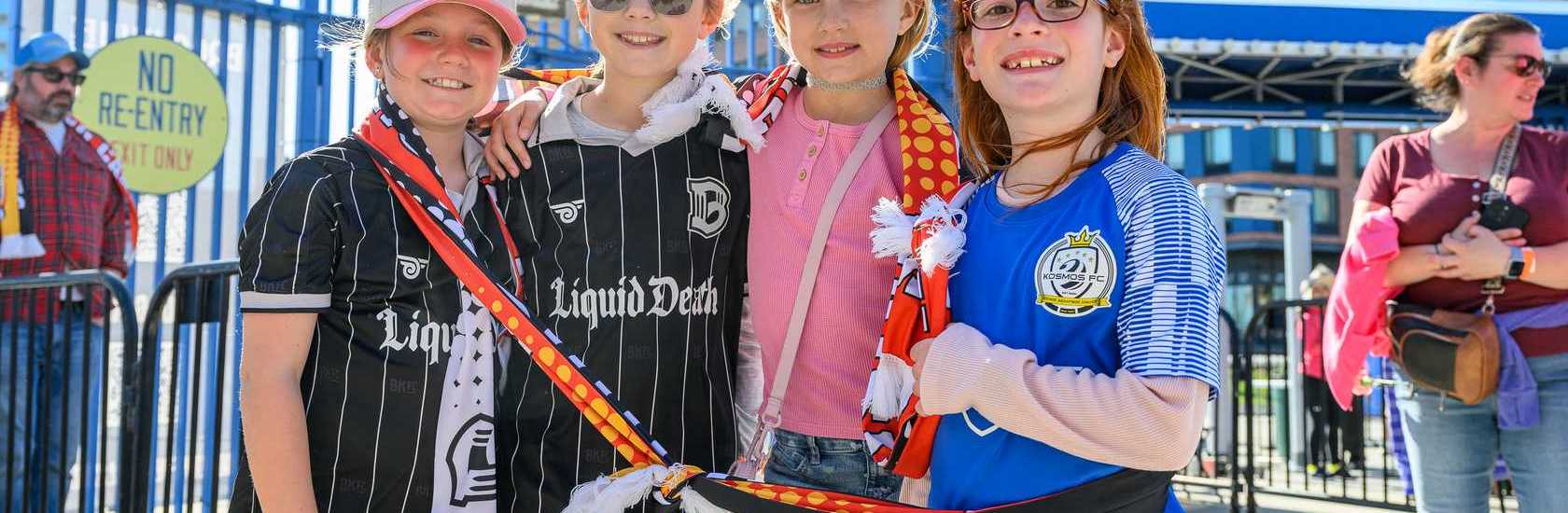 Young fans at a Brooklyn FC match cheering for their team